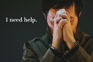 Handcuffed male prisoner in military uniform praying for help