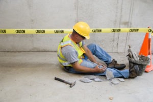 A construction worker grabs his knee after an accident