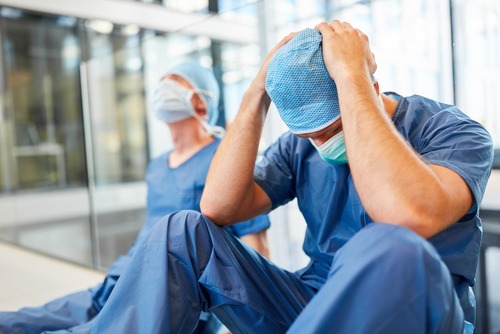 A surgeon holds his head