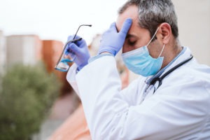 distressed doctor removing his glasses