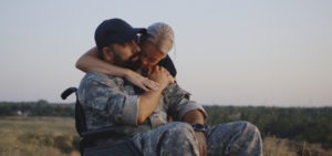 woman hugging a veteran in a wheelchair